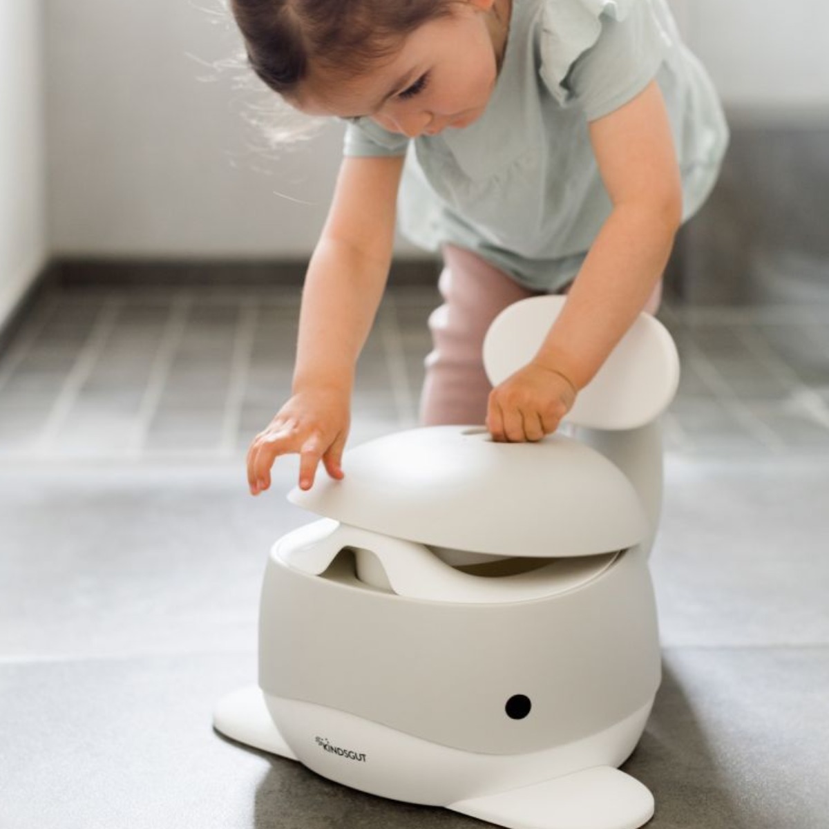 Mädchen entdeckt spielend das Kindertöpfchen