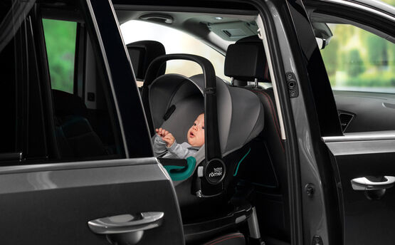 Kind im Britax Römer Baby-Safe 3 i-Size rückwärtsgerichtet auf der Rückbank eines Fahrzeugs