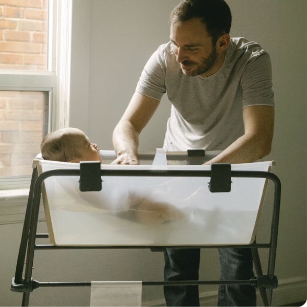 Baby wird entspannt in der Stokke Flexi Bath gebadet und genießt einen ruhigen Moment mit einem Elternteil.